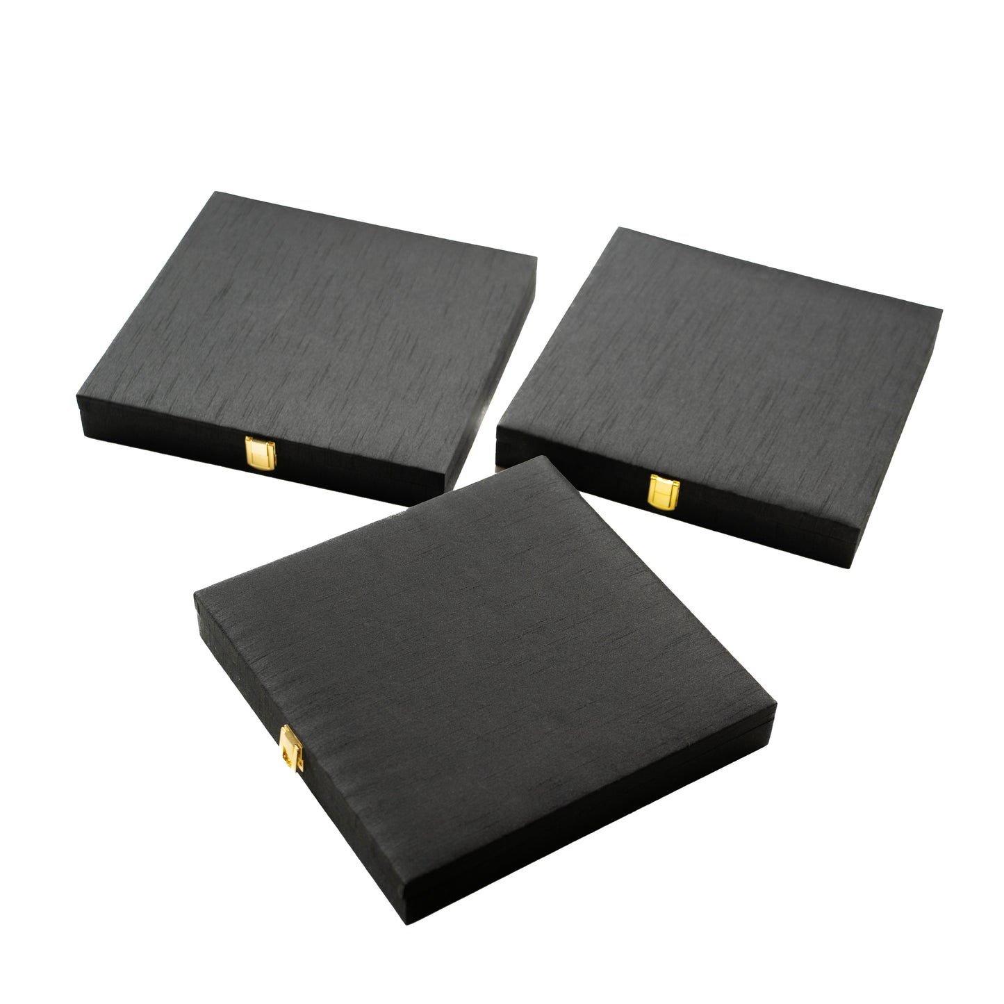 Three black square boxes with gold accents .