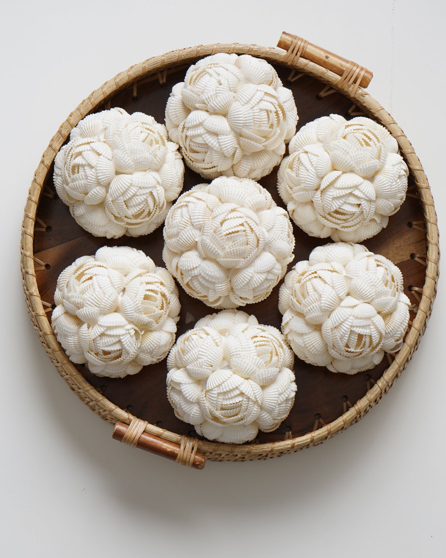 Decorative white cauliflower-like sculptures in a woven basket on a light background