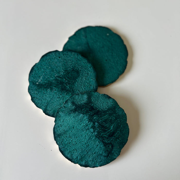 Two teal scrunchies on a white background