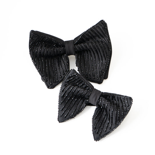 Two black ribbed bow tie on a white background