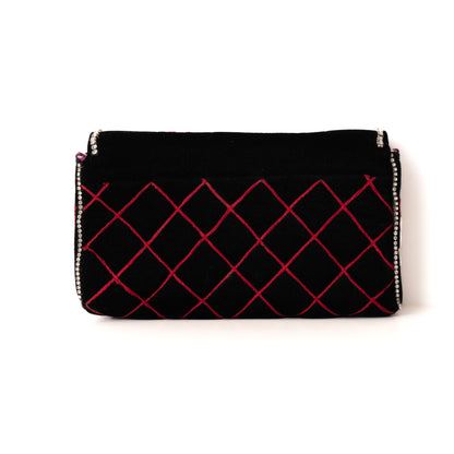 Black clutch with red lattice pattern on a white background