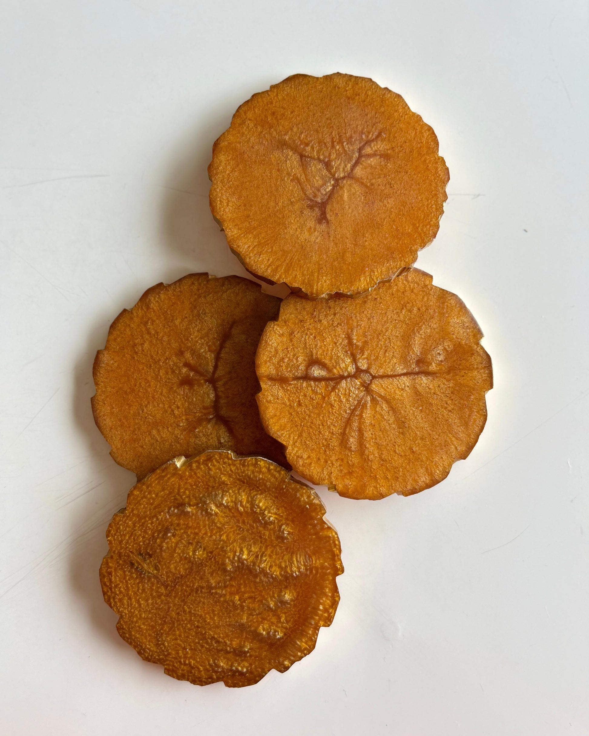 Four dried persimmon slices on a white background