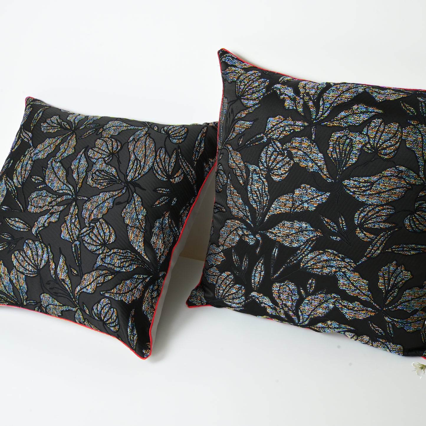 Two decorative pillows with leaf pattern .