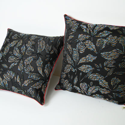 Two decorative pillows with leaf pattern .