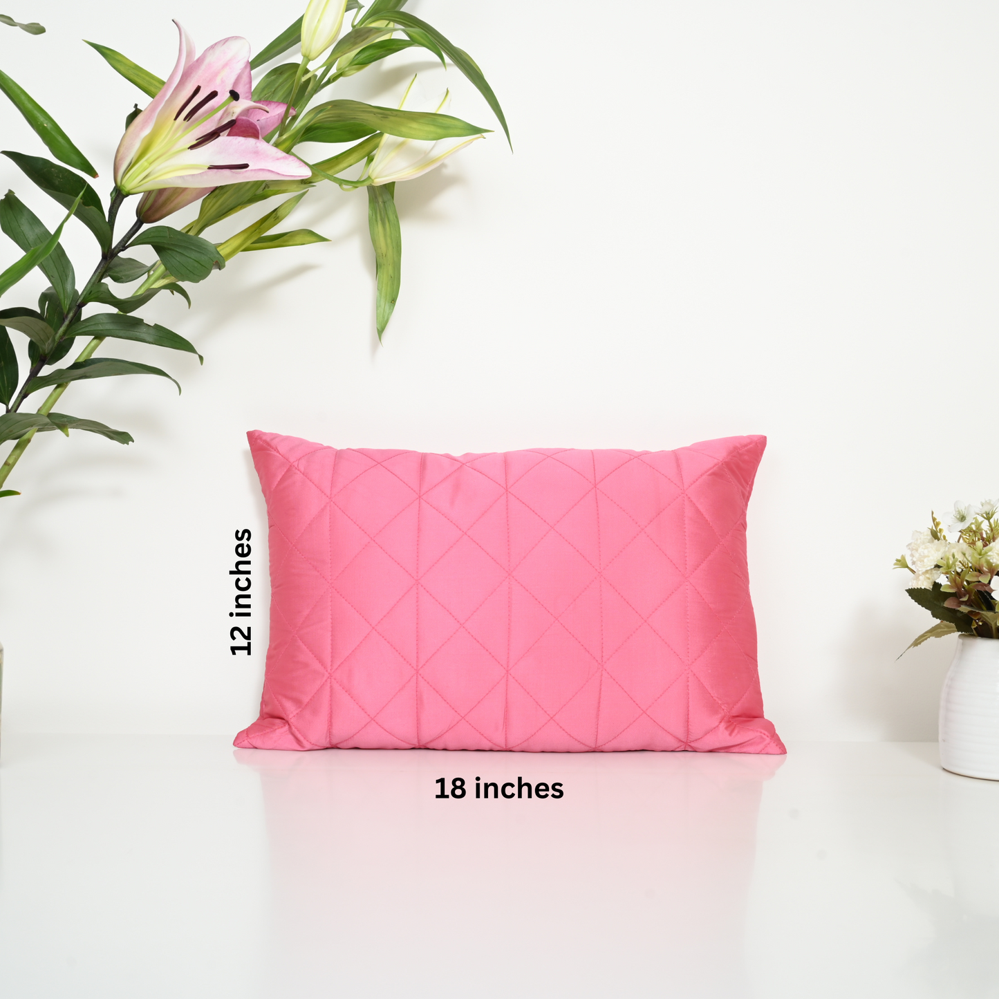 Pink pillow with measurements on a white background.