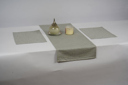 Table setting with a rectangular tablecloth, placemats, and a candle on a white background