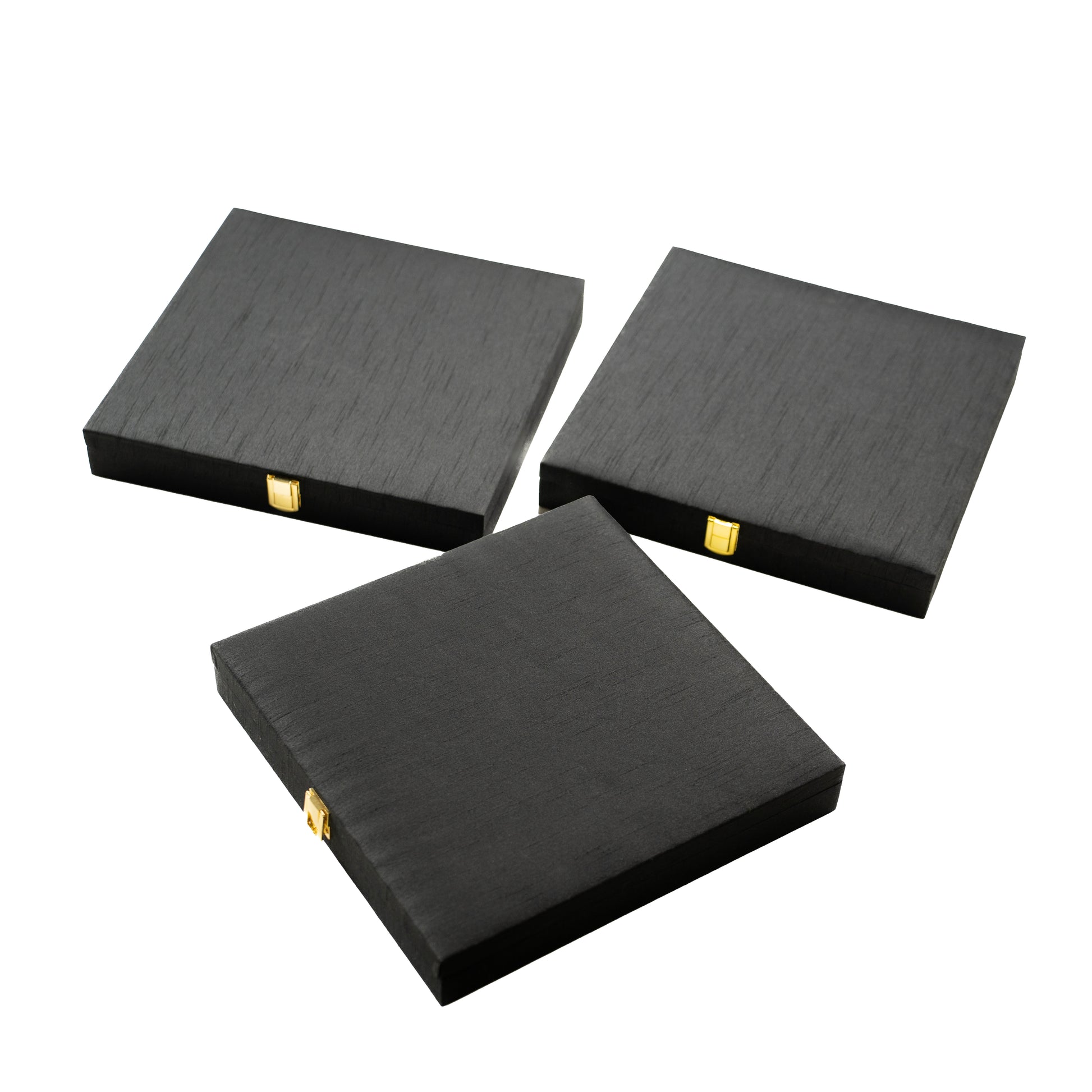 Three black square boxes with gold accents .