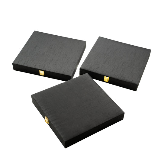 Three black square boxes with gold accents .