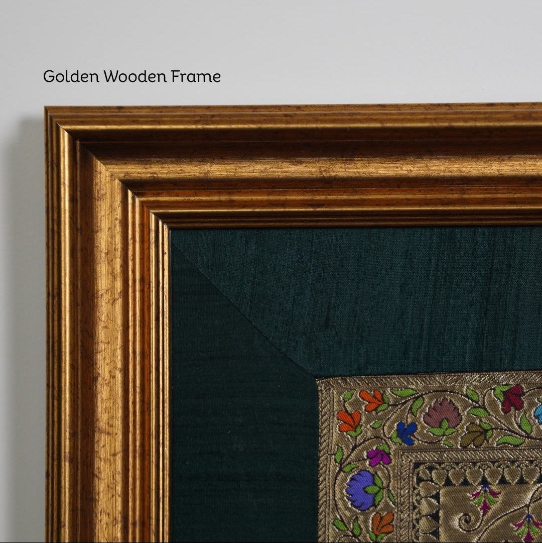 Close-up of a golden wooden frame with embroidered artwork on a gray background