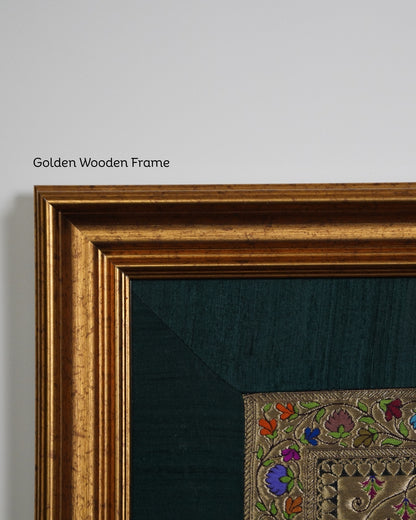Close-up of a golden wooden frame with embroidered artwork on a gray background