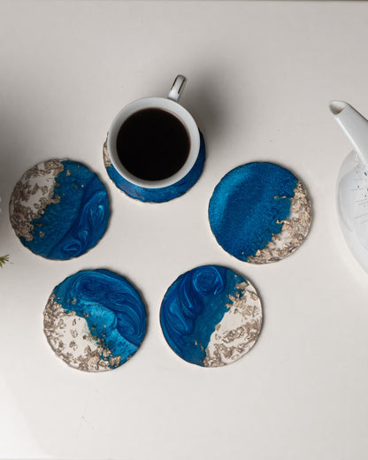 Blue and white marbled coasters with a cup of coffee on a light surface.