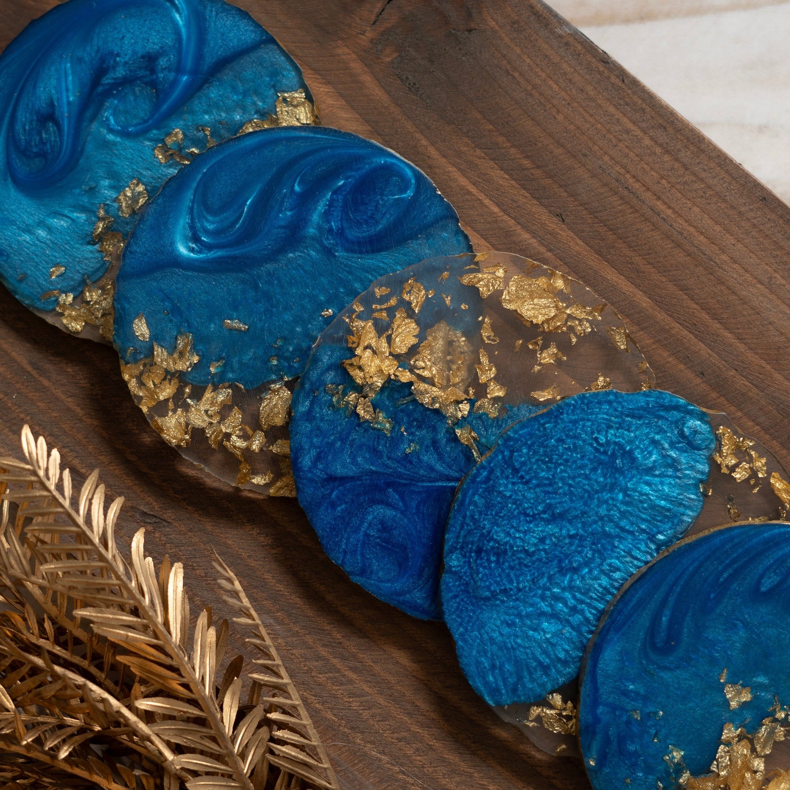 Blue and gold decorative items on a wooden surface with gold leaves.