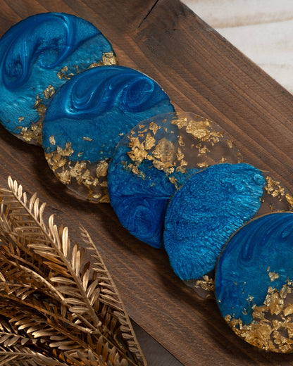 Blue and gold decorative items on a wooden surface with gold leaves.