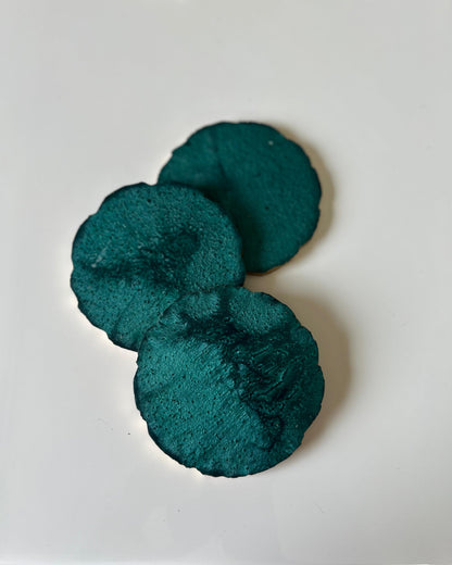 Two teal scrunchies on a white background
