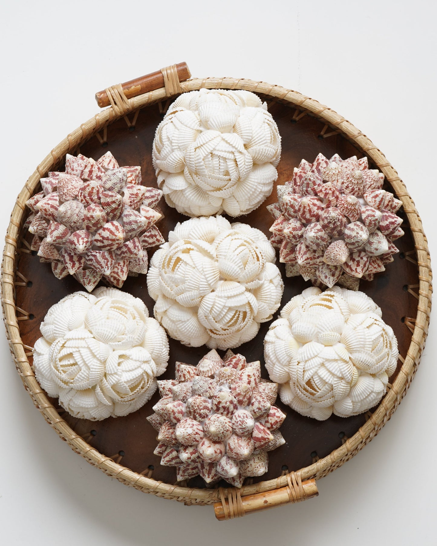 Decorative items resembling flowers in a woven basket on a white background