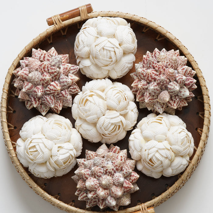 Decorative items resembling flowers in a woven basket on a white background