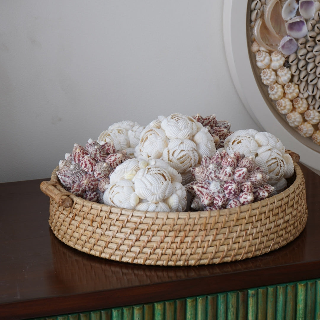 Decorative basket with white and pink coral-like sculptures on a wooden surface.