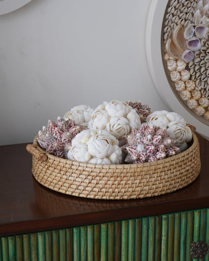 Decorative basket with white and pink coral-like sculptures on a wooden surface.