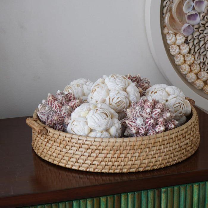Decorative basket with white and pink coral-like sculptures on a wooden surface.