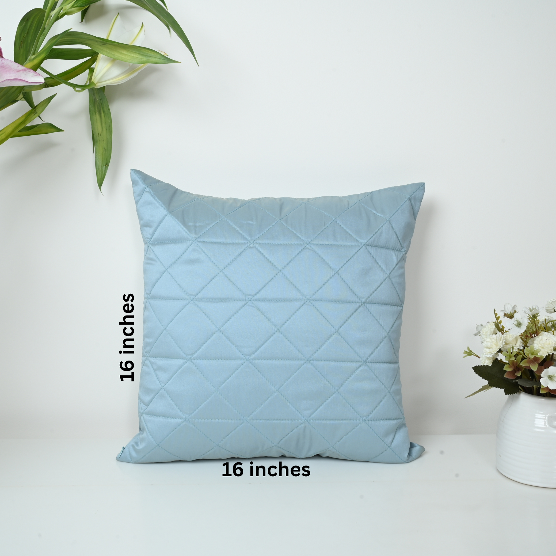 Light blue quilted pillow with dimensions on a white background